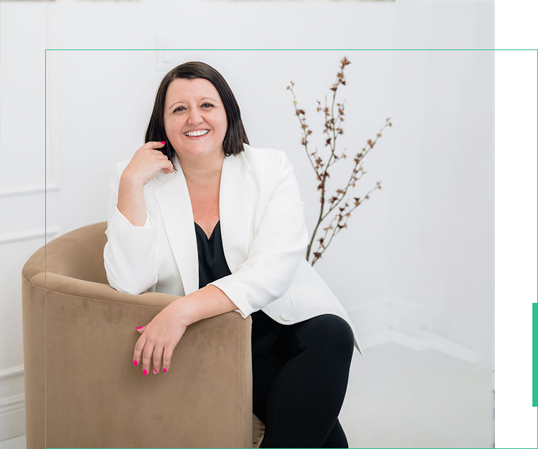 A woman sitting on top of a chair in front of a wall.