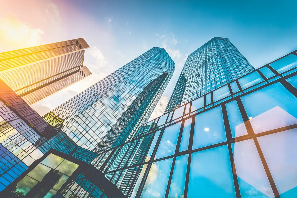 A view of three skyscrapers from below.