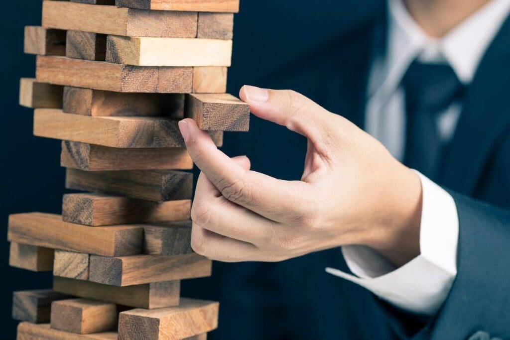 A person playing with wooden blocks in front of him.