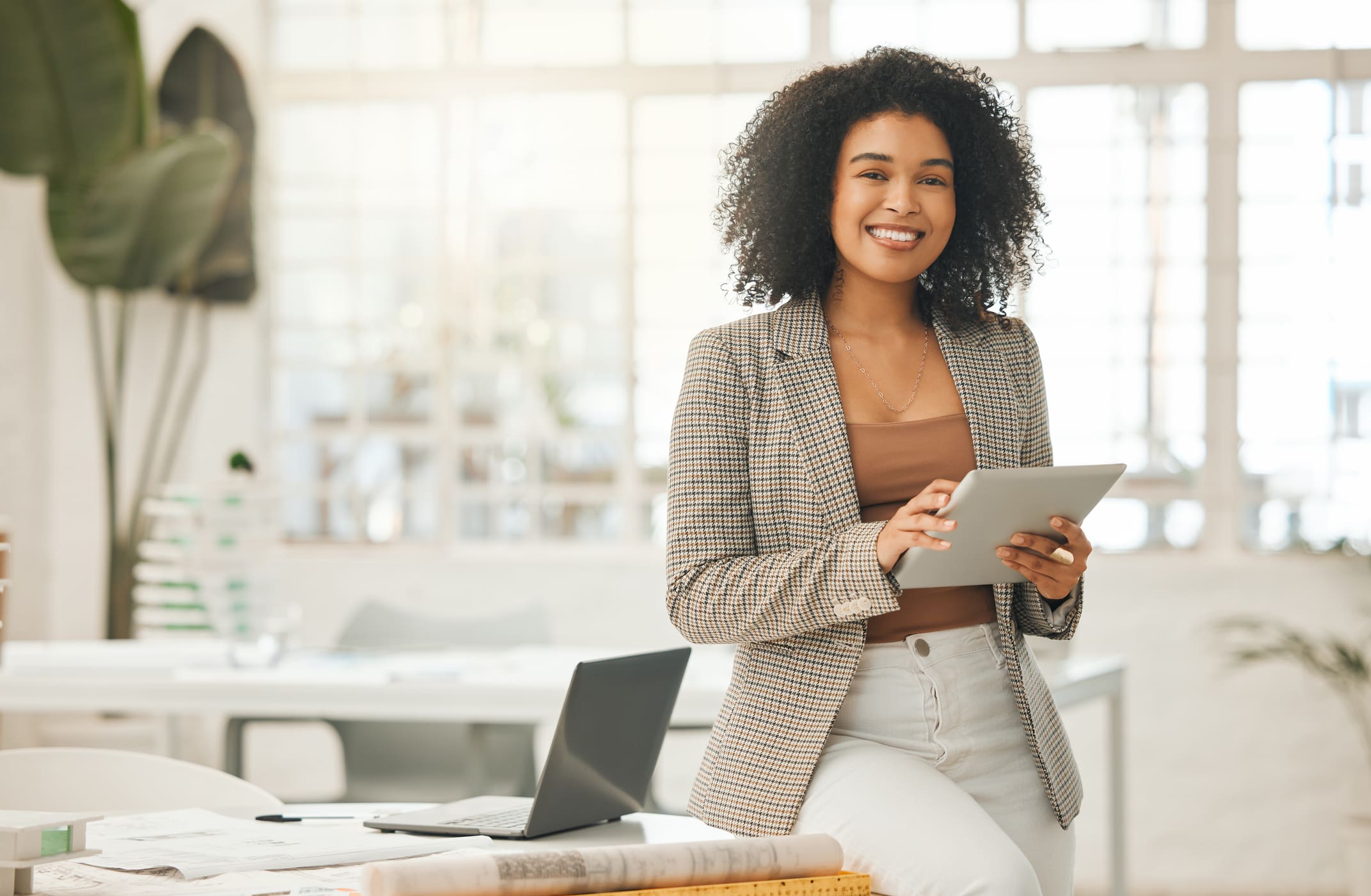 A woman standing in front of a table with a laptop.