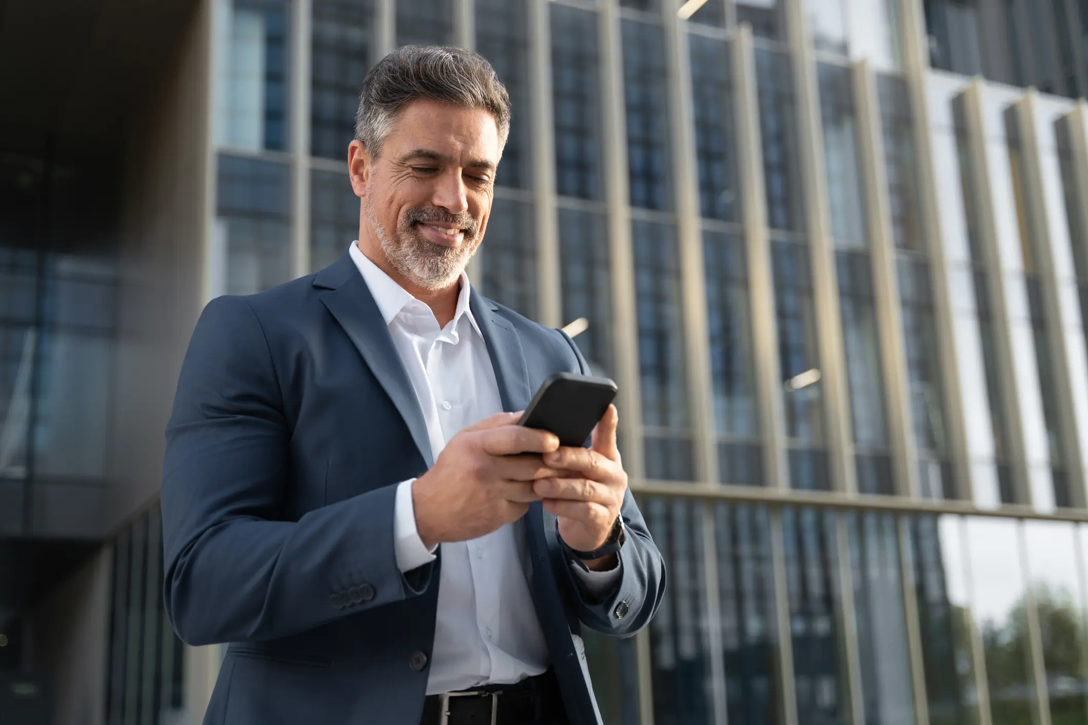 A man in suit and tie looking at his phone.